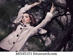 Fine ART style photo of a gorgeous brunette holding branch