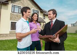 Young couple signing renting contract with real estate agent. agent giving pen to sign agreement for house sale