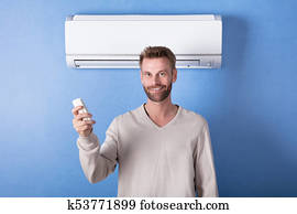 Young Man Standing In Front Of Air Condition
