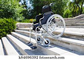 Wheelchair near the steps in a spring park. Wheelchair near the steps in a spring park.