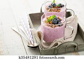 Blueberry smoothie with granola in glass mugs Blueberry smoothie with granola in glass mugs