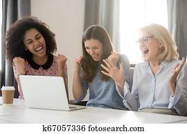 diverso, feliz, alborozada, hembra, empleados, equipo, excitado, por, en línea, victoria