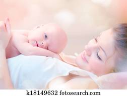 Happy Mother and her Newborn Baby Kissing and hugging Happy Mother and her Newborn Baby Kissing and hugging