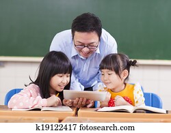 Teacher teaching children with digital tablet or ipad Teacher teaching children with digital tablet or ipad