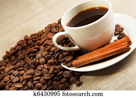 cup of coffee with tubes of cinnamon