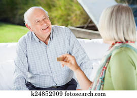 Senior Couple Talking While Playing Dominoes