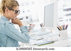 Blonde focused designer working at her desk Blonde focused designer working at her desk