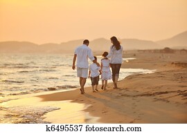 happy young family have fun on beach at sunset happy young family have fun on beach at sunset