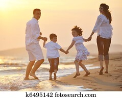 happy young family have fun on beach at sunset
