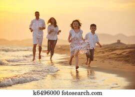 happy young family have fun on beach at sunset