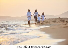 happy young family have fun on beach at sunset happy young family have fun on beach at sunset
