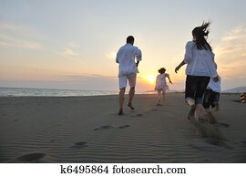 happy young family have fun on beach at sunset happy young family have fun on beach at sunset