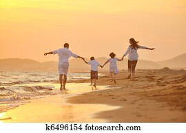 happy young family have fun on beach at sunset happy young family have fun on beach at sunset
