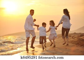 happy young family have fun on beach at sunset happy young family have fun on beach at sunset