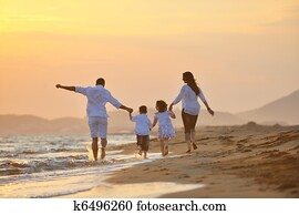 happy young family have fun on beach at sunset happy young family have fun on beach at sunset