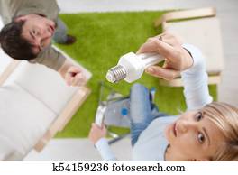 Woman changing light bulb