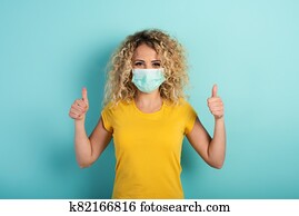 Girl is optimistic about the defeat of covid 19 coronavirus. Cyan background Girl is optimistic about the defeat of covid 19 coronavirus. Cyan background