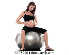 Pregnant Woman Happy sitting on swiss ball fitness
