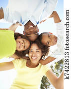 Portrait of Happy Family Looking Down Into Camera In Park