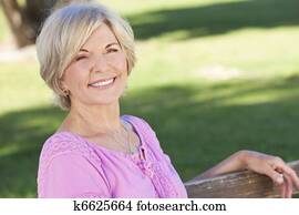 Happy Senior Woman Sitting Outside Smiling