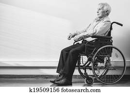 Thoughtful senior man in wheelchair in nursing home