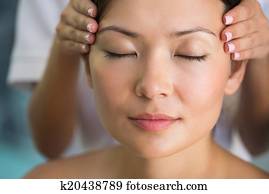 Relaxed brunette getting a head massage