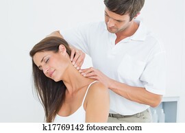 Male chiropractor massaging a young woman's neck Male chiropractor massaging a young woman's neck