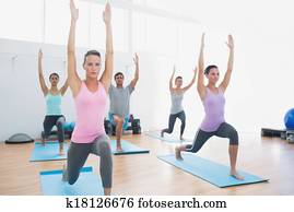 Class doing pilate exercises in fitness studio