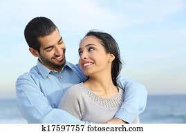Arab casual couple cuddling happy with love on the beach