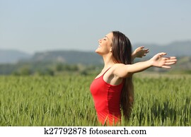 Woman breathing deep fresh air in a field