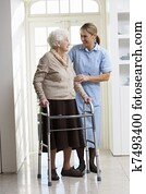 Carer Helping Elderly Senior Woman Using Walking Frame