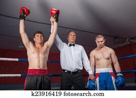 dois, pugilista, homens, ficar, em, ring., árbitro, levantamento, vencedor, mão, anunciar, vitória