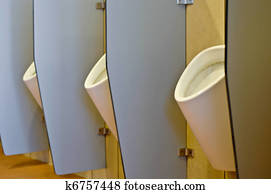 Urinals behind partitions in a toilet in office building