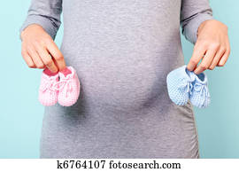Pregnant woman holding baby booties