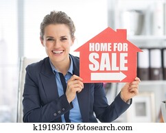 Happy realtor woman showing home for sale sign