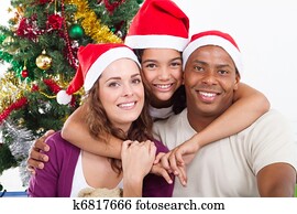 family sitting near Christmas tree
