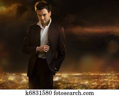 Elegant young handsome man over night city background