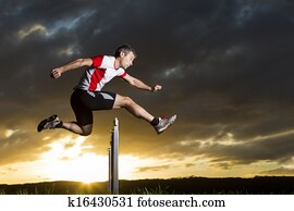 athlete hurdling in sunrise athlete hurdling in sunrise