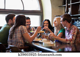 happy friends with beer eating at bar or pub happy friends with beer eating at bar or pub