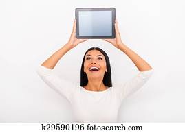 hon, likar, smart, gadgets., glad, ung kvinna, holdingen, digital tablet, ovanför, henne, huvud, medan, stående, mot, vit fond