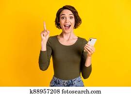 צילום, של, אישה צעירה, החזק, טלפן, הרם, , אצבע מורה, פה פתוח, לבש, חולצה ירוקה, הפרד, חזק, צהוב, צבע רקע