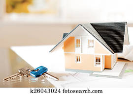 Architectural Miniature Home on Blueprint with Key