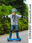 Happy boy riding on hoverboard or gyroscooter outdoor