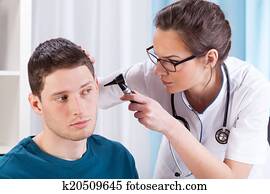 Young doctor examining patient's ears