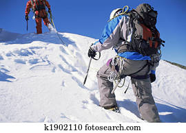 Young men mountain climbing on snowy peak
