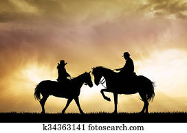 couple on horseback at sunset couple on horseback at sunset