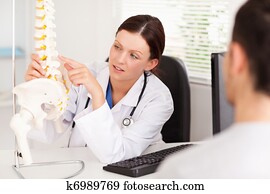 Female doctor pointing on a bone Female doctor pointing on a bone