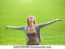 Carefree older woman smiling with arms open