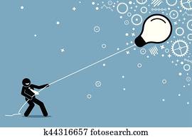 Businessman pulling a flying floating light bulb on a string.