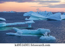 icebergs in quiet bay at sunset
